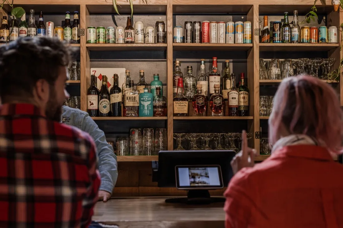 The full bar at The Daily Brew with shelves of spirits, beer and glassware