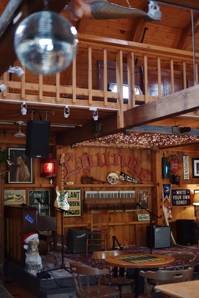 The wood-paneled Lounge with a disco ball, loft and vintage signs